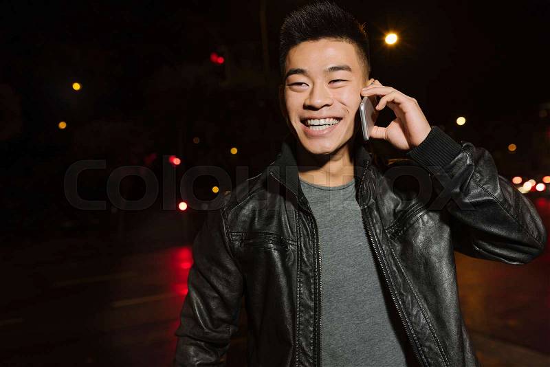 Handsome asian young man with mobile phone in the city, stock photo