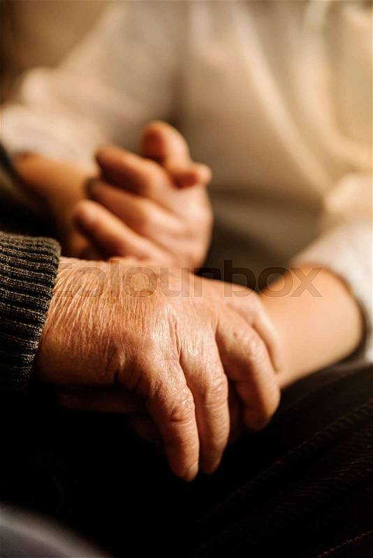 Hand of old person holding hand of kid. Old Age Concept, stock photo