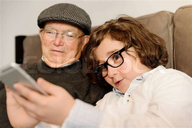 Grandfather and grandson are taking selfie at home, stock photo