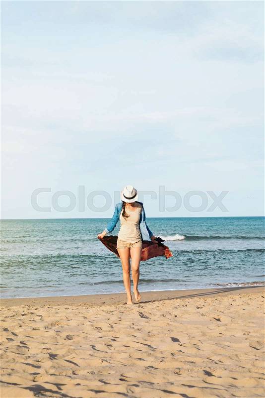 Pretty woman walking away on the idylic beach, stock photo