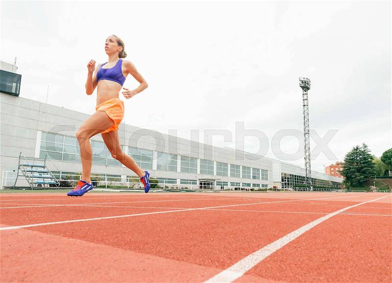 Athletics woman Track Athlete Running On Track. She is on stadium, stock photo