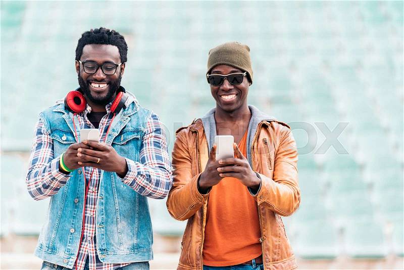 Two black race friends having fun with mobile. Friends Concept, stock photo