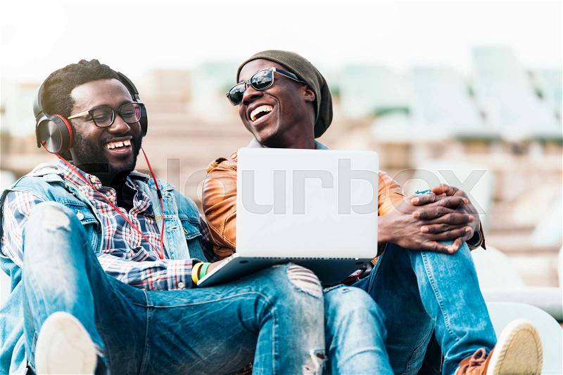 Two black race friends having fun with laptop. Friends Concept, stock photo