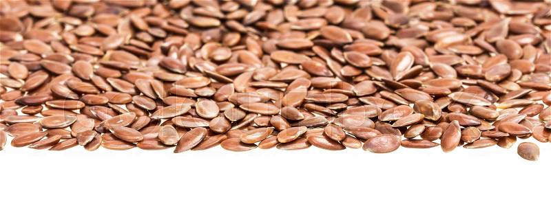 Linseed or flax seed for upper page border with focus on inner edge and isolated on white, stock photo