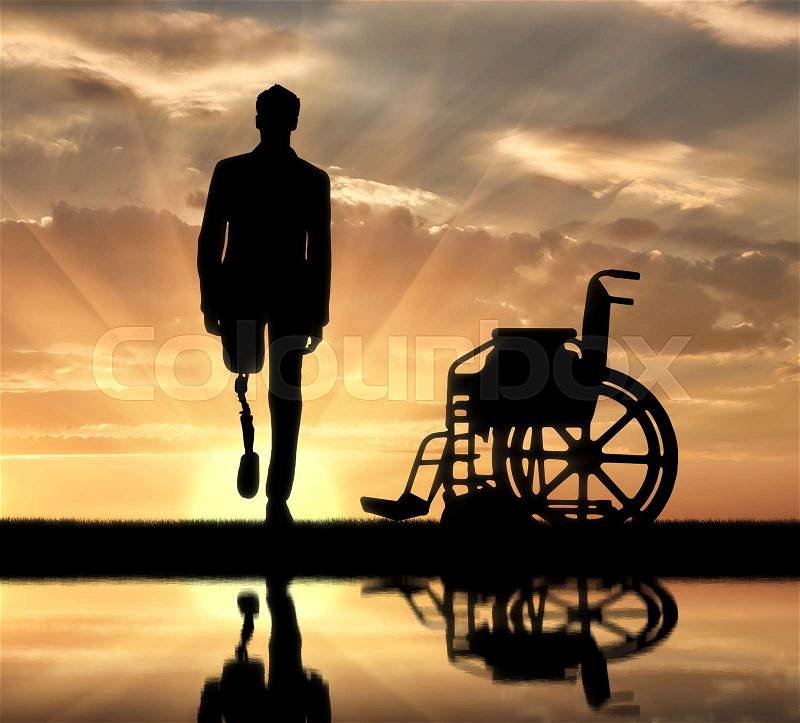 Disability and rehabilitation. Walking is a disabled man with a prosthetic leg and a wheelchair near the river, stock photo