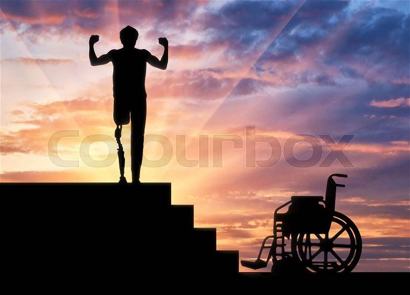 Disability and rehabilitation. Happy disabled man with a prosthetic leg walked up the stairs, and a wheelchair, stock photo