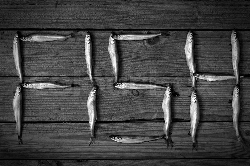 The word fish from fish on a wooden background, black and white, stock photo
