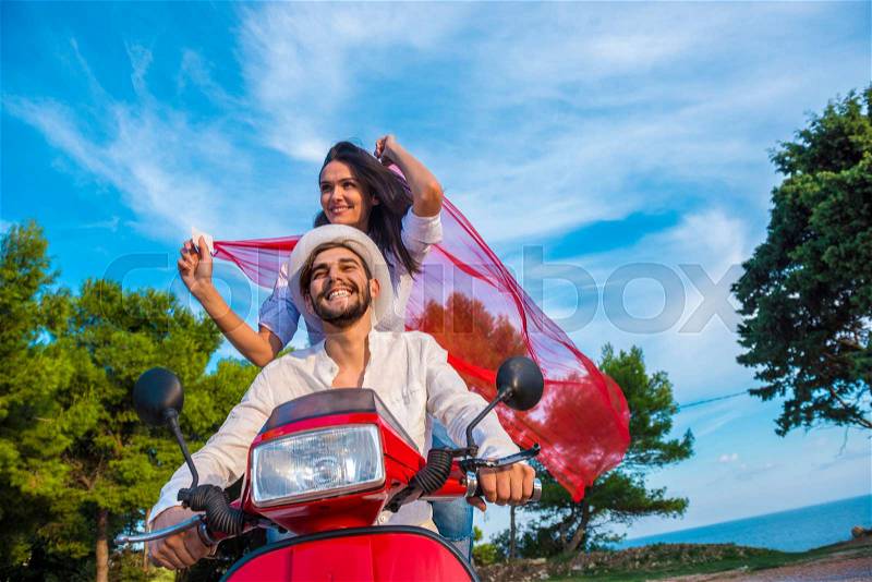 Happy free freedom couple driving scooter excited on summer holidays vacation. Young multiethnic couple, stock photo