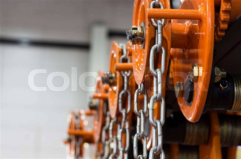 Industrial Steel Chains in orange hoists ; Selective focus , stock photo