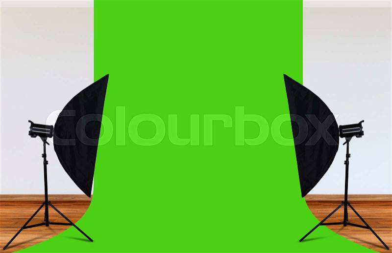 Photo studio with lighting equipment and green backdrop, stock photo