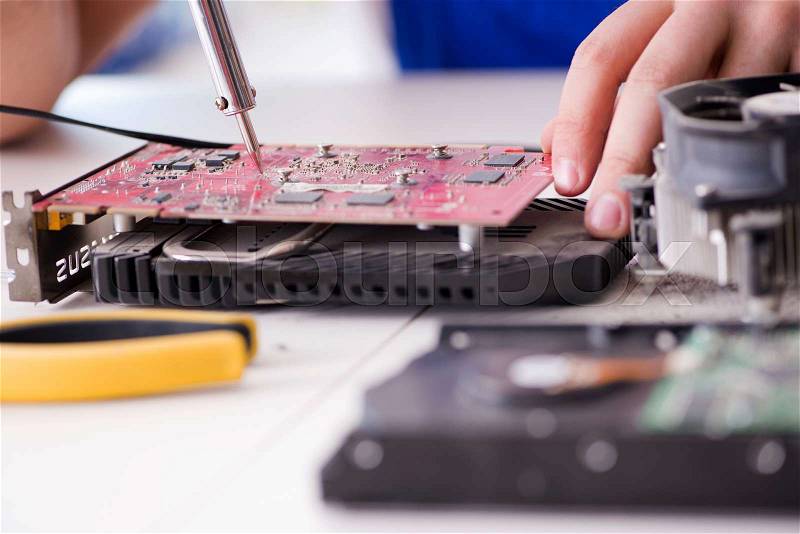 Computer repairman repairing desktop computer, stock photo