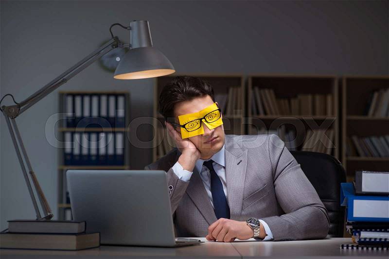 Businessman staying late to sort out priorities, stock photo