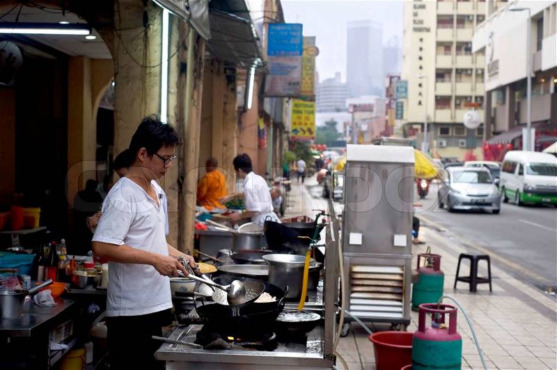 Kuala Lumpur, Malaysia - March 17, 2011: Local man cooking fast food on the street in Kuala Lumpur\'s Chinatown KL Chinatown is a popular tourist attraction and a food haven, stock photo