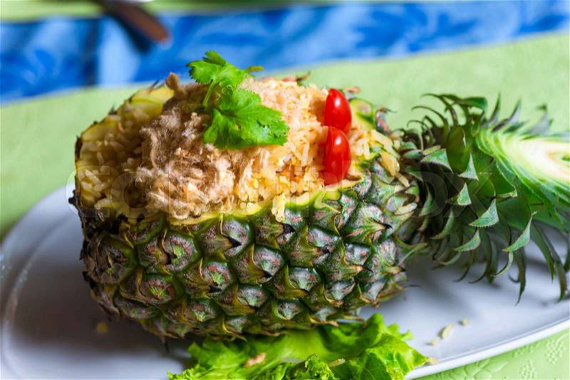 Pineapple stuffed with fried rice and chicken is nicely served on a plate, stock photo