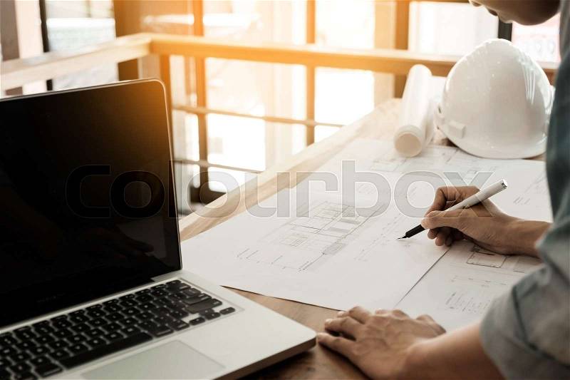 Architects engineer discussing at the table with blueprint - Closeup on hands and project print, stock photo