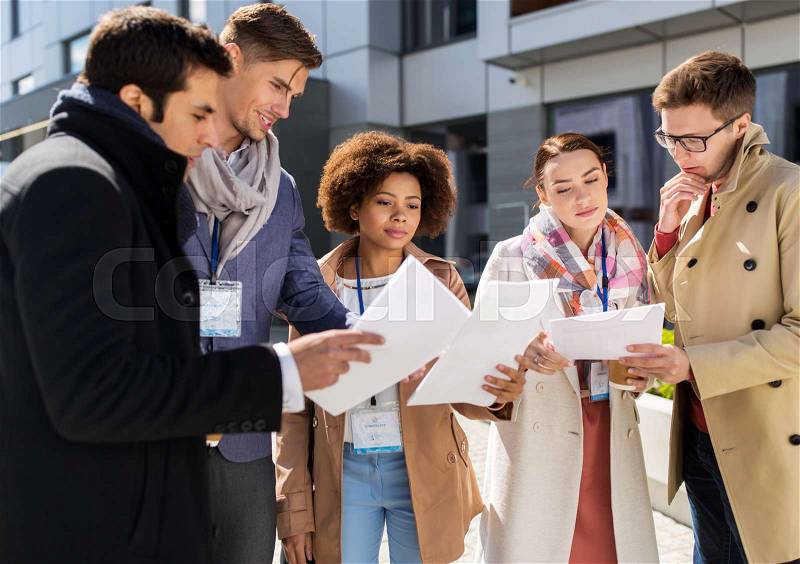 Business, education and corporate concept - international group of people with papers and coffee cups on city street, stock photo