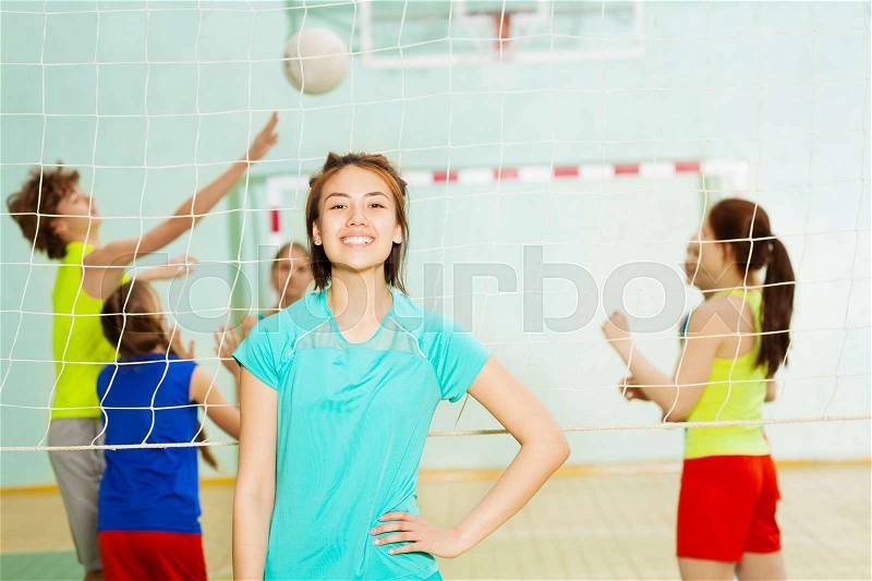Portrait of happy Asian girl, volleyball player, standing in gymnasium during the match, stock photo
