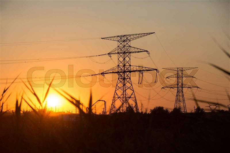 High voltage transmission power line silhouette on sunset, stock photo