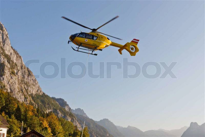 Yellow emergency helicopter in the Austrian Alps, Traunsee, Austria, stock photo