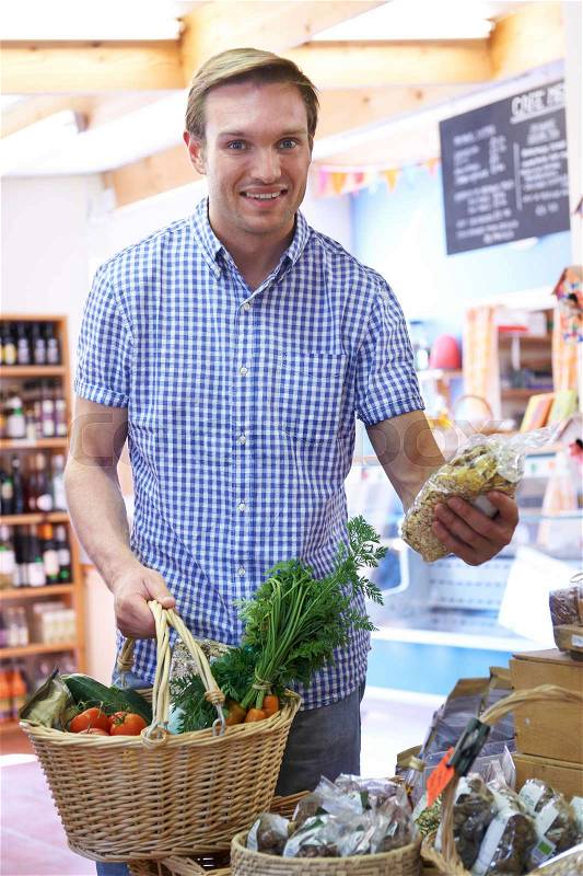 Male Shopper In Delicatessen Buying Organic Produce, stock photo