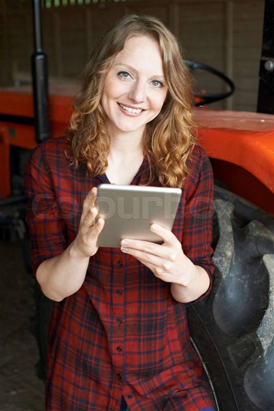 Female Agricultural Worker On Farm Using Digital Tablet, stock photo