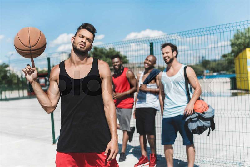 Multicultural basketball team spending time on basketball court, stock photo