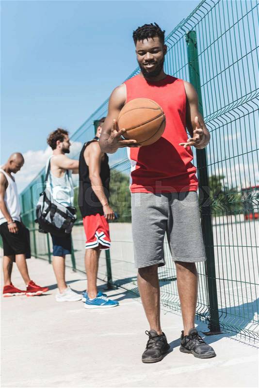 Multicultural basketball team spending time on basketball court, stock photo