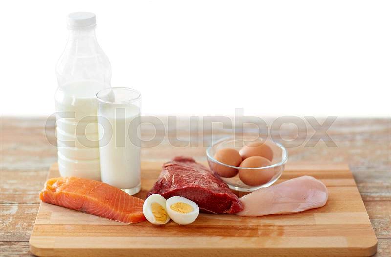 Natural food, healthy eating and protein diet concept - raw meat fillet, fish, milk and eggs on wooden table, stock photo