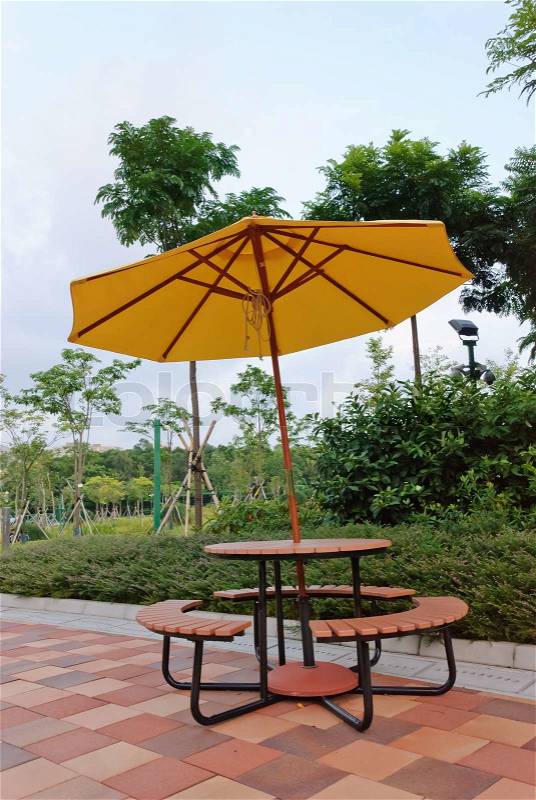Patio umbrella with blue sky and tree background, stock photo