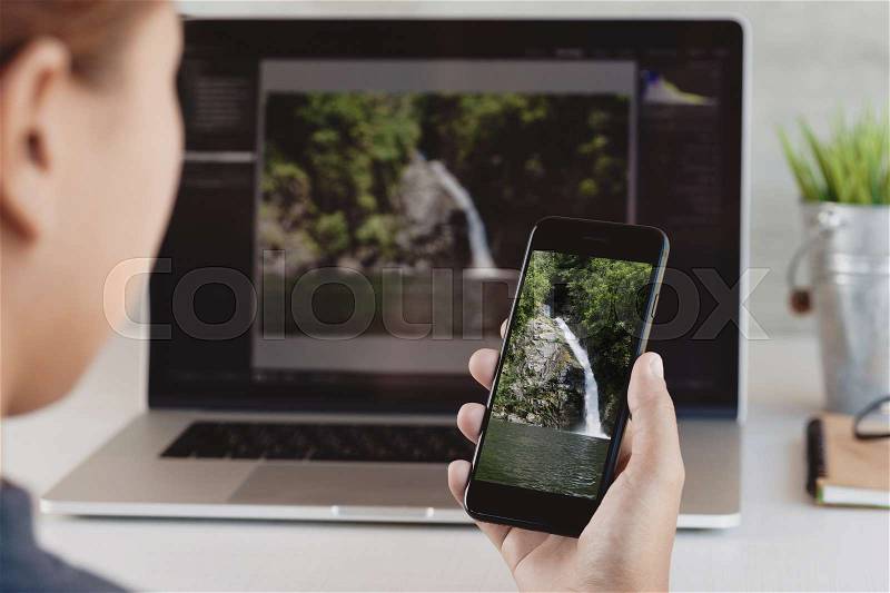 Close-up woman holding phone and looking in office workplace, stock photo