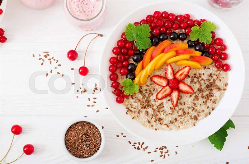 Tasty and healthy oatmeal porridge with berry, flax seeds and smoothies. Healthy breakfast. Fitness food. Proper nutrition. Top view. Flat lay, stock photo
