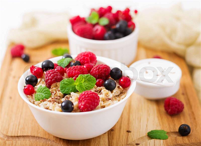 Tasty and healthy oatmeal porridge with berry, flax seeds and yogurt. Healthy breakfast. Fitness food. Proper nutrition, stock photo