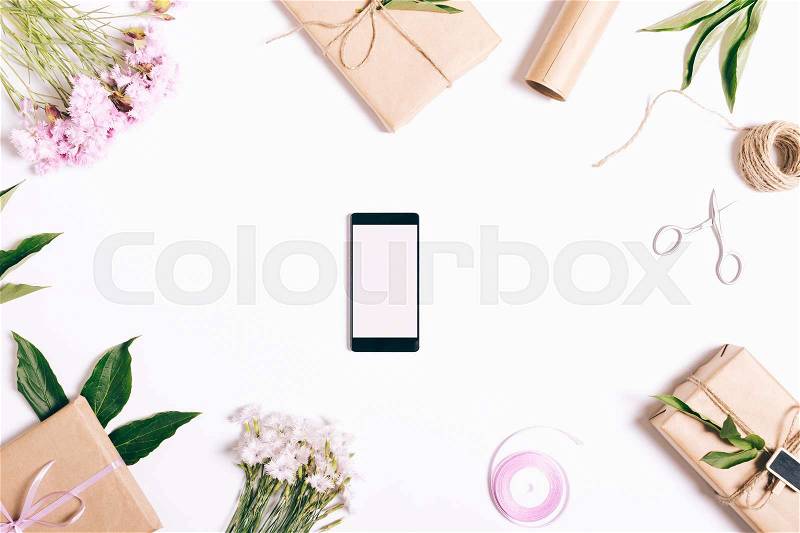 Mobile phone lying on the table with decorations, top view, stock photo