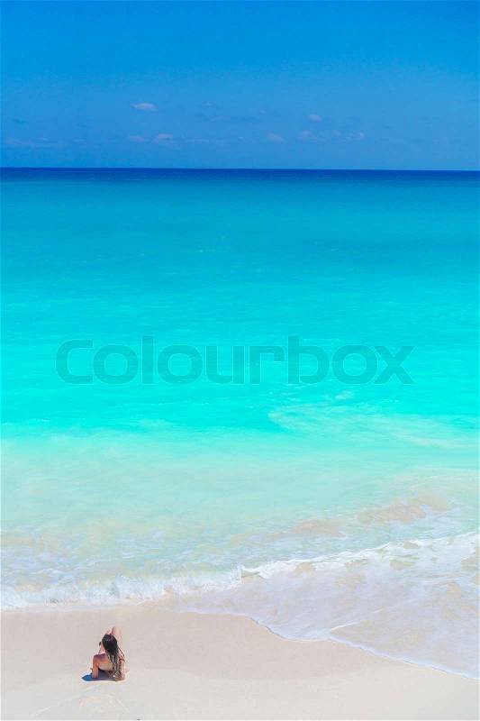 Young beautiful girl on the beach at shallow tropical water top view, stock photo