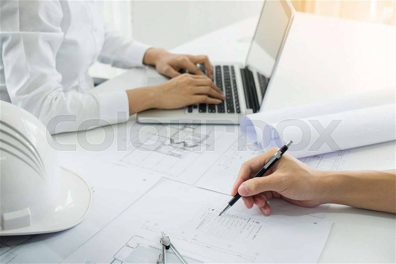 Architects engineer discussing at the table with blueprint - Closeup on hands and project print, Team group on construciton site check documents and business workflow, stock photo