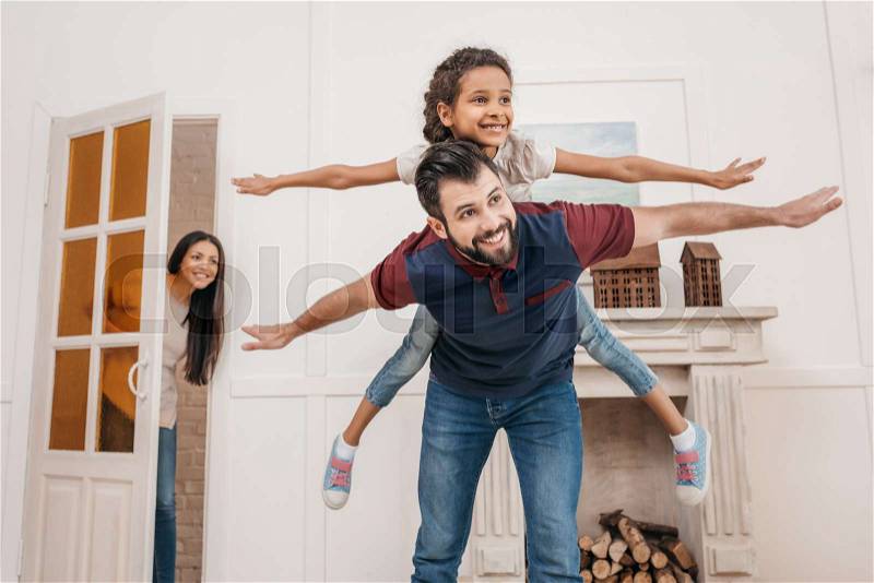 Happy father piggybacking cute little daughter at home, stock photo