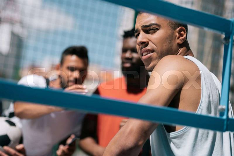 Multiethnic group of young men sitting on stadium together, stock photo
