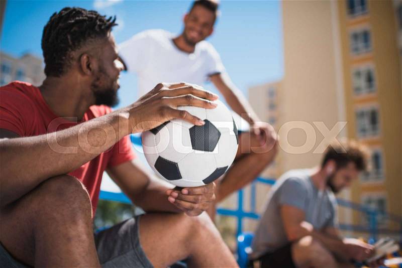 Selective focus of african american man holding soccer ball, stock photo