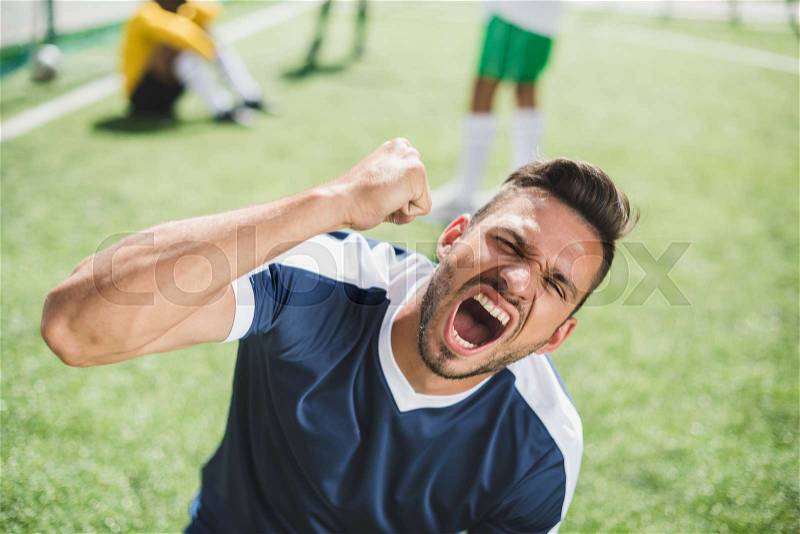 Portrait of happy soccer player celebrating goal during soccer match, stock photo
