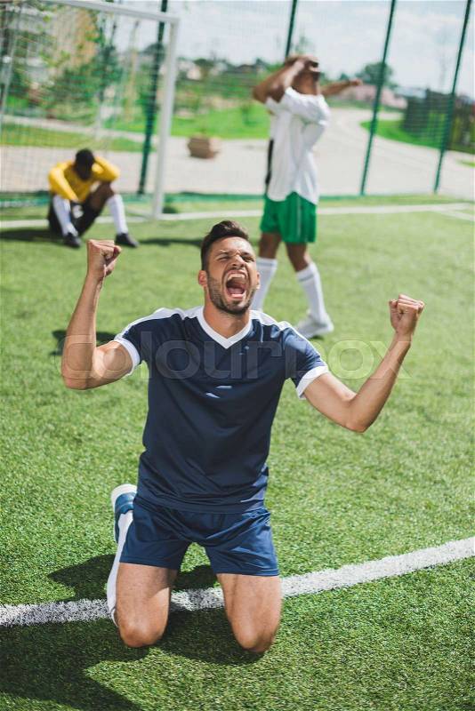 Happy soccer player celebrating goal during soccer match, stock photo