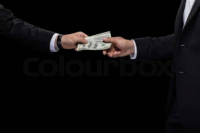 Cropped view of businessman giving money and bribing business partner, isolated on black, stock photo