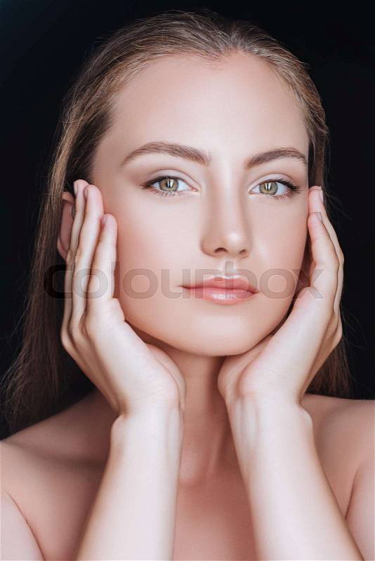 Portrait of beautiful smiling woman with hands near face isolated on black, stock photo