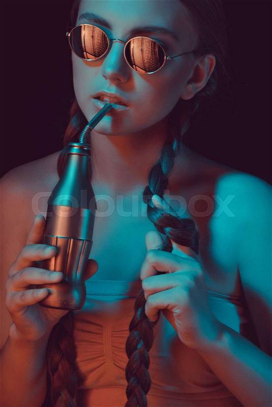Woman with braids drinking soda from water bottle with straw, stock photo