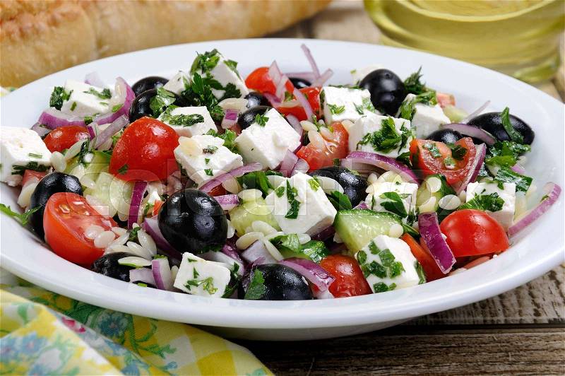 Greek salad orzo pasta with black olive, red onion and cucumber, cherry tomatoes, feta and herbs. Horizontal shot. foreground, stock photo