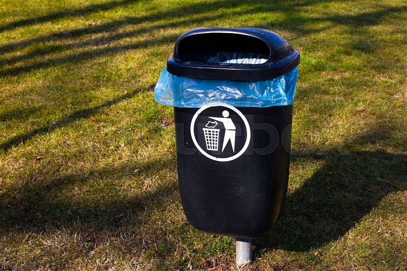 Plastic garbage bin on grass. Sorted waste. Throw out. Park trash bin, rubbish, stock photo