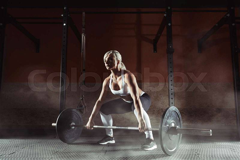 Muscular young fitness woman lifting a weight in the gym. Fitness woman deadlift barbell. Fitness woman, stock photo