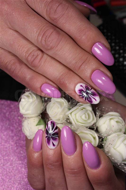 Manicure design nails in purple with a pattern of lilies, stock photo