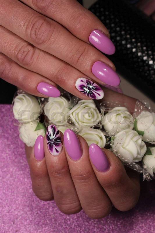 Manicure design nails in purple with a pattern of lilies, stock photo