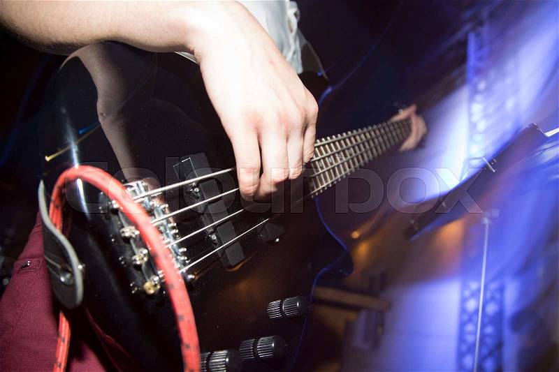 Musician playing guitar in a rock band , stock photo