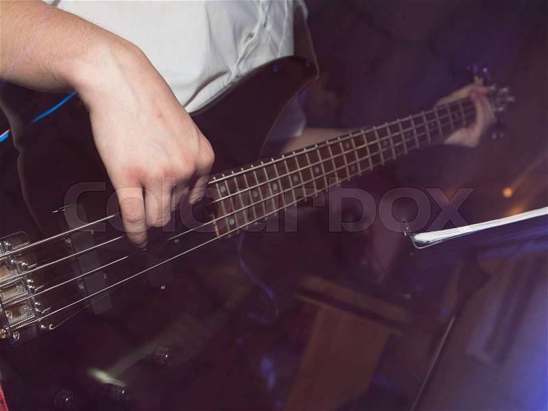 Musician playing guitar in a rock band , stock photo